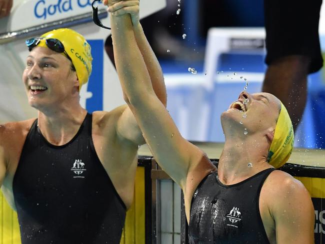 Bronte Campbell of Australia celebrates, as Cate Campbell of Australia looks on,  after winning the Womenâ€™s 100m Freestyle Final on day five of swimming competition at the XXI Commonwealth Games at Gold Coast Aquatic Centre on the Gold Coast, Australia, Monday, April 9, 2018. (AAP Image/Darren England) NO ARCHVIING, EDITORIAL USE ONLY