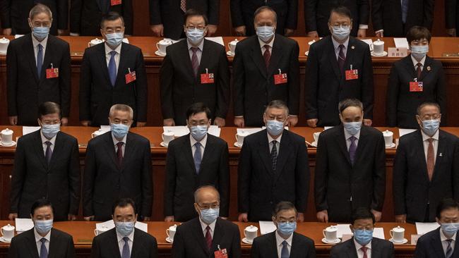 Chinese Communist Party delegates, all wearing protective masks, stand during the national anthem at the opening of the National People's Congress at the Great Hall of the People on May 22, 2020 in Beijing, China.