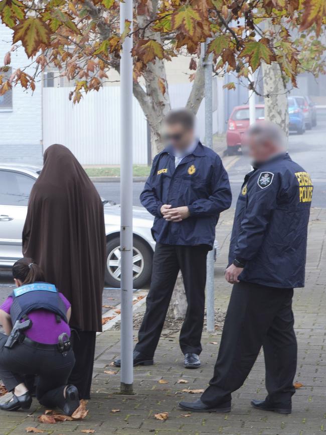 The woman is arrested by Australian Federal Police in Adelaide’s western suburbs on Tuesday. Picture: AFP