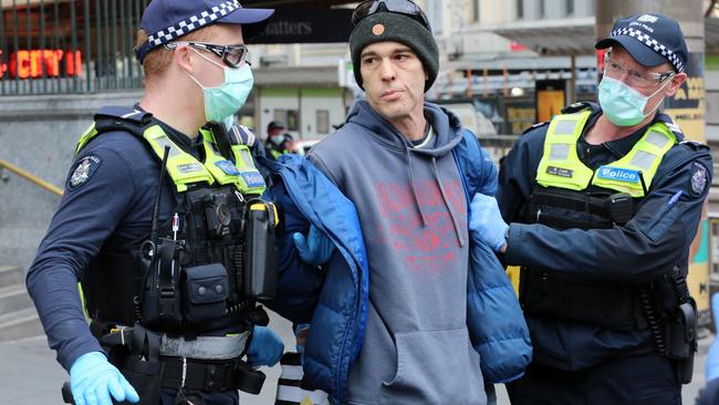 Police with a protester. Picture: Matrix