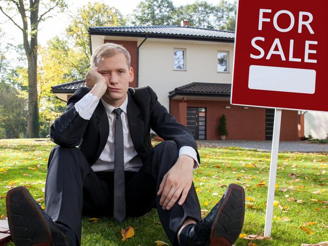 Worried real estate agent and house for sale