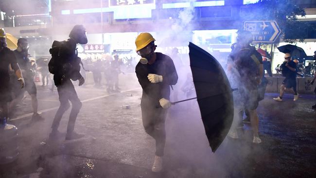 Hong Kong protesters are enveloped by tear gas let off by police on Sunday night. Picture: AFP