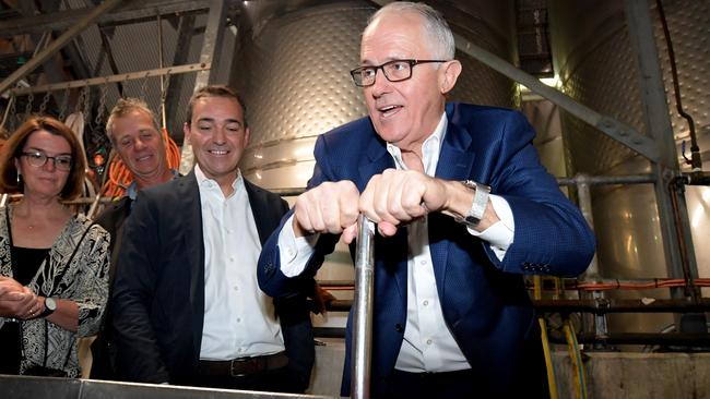 South Australian Liberal leader Steven Marshall looks on as Prime Minister Malcolm Turnbull plunges a vat of grapes during a visit to Wirra Wirra Vineyards in McLaren Vale, Saturday, March 10, 2018. AAP Image/Tracey Nearmy.