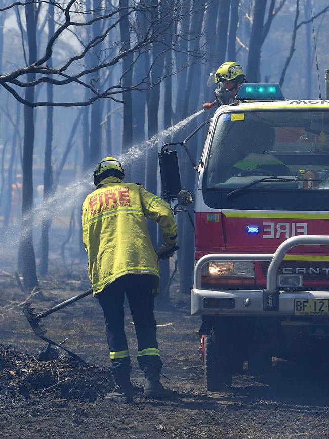 Fire and Rescue NSW crews mop up after a grass fire impacted a property on Fourth Ave, Llandilo. Picture: Dan Himbrechts