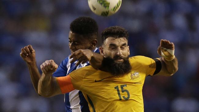 Mile Jedinak fights for the ball with Anthony Lozano in the World Cup playoff first leg.