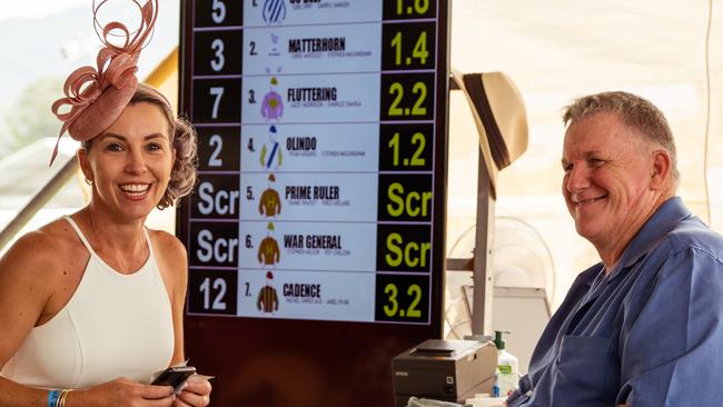 Christie Innes from Cairns places a bet with local bookie Jeff Downs at the Cairns Amateurs. Picture: Emily Barker.