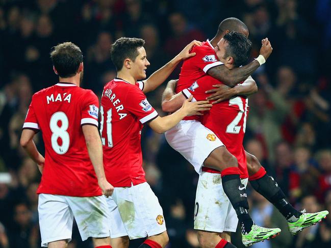 MANCHESTER, ENGLAND - NOVEMBER 29: Robin van Persie of Manchester United (R) celebrates scoring their third goal with team mates during the Barclays Premier League match between Manchester United and Hull City at Old Trafford on November 29, 2014 in Manchester, England. (Photo by Clive Mason/Getty Images)