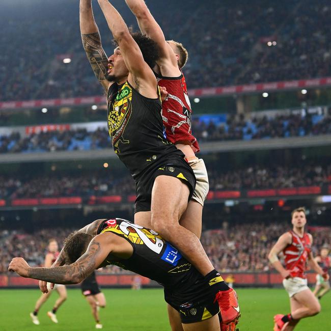 Richmond star Shai Bolton (bottom) was concussed in this final-quarter collision with teammate Mykelti Lefau and Essendon defender Ben McKay. Picture: Morgan Hancock / Getty Images