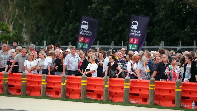 People queued at Pacific Fair interchange for transport to the opening ceremony at Metricon. Photo: Richard Gosling