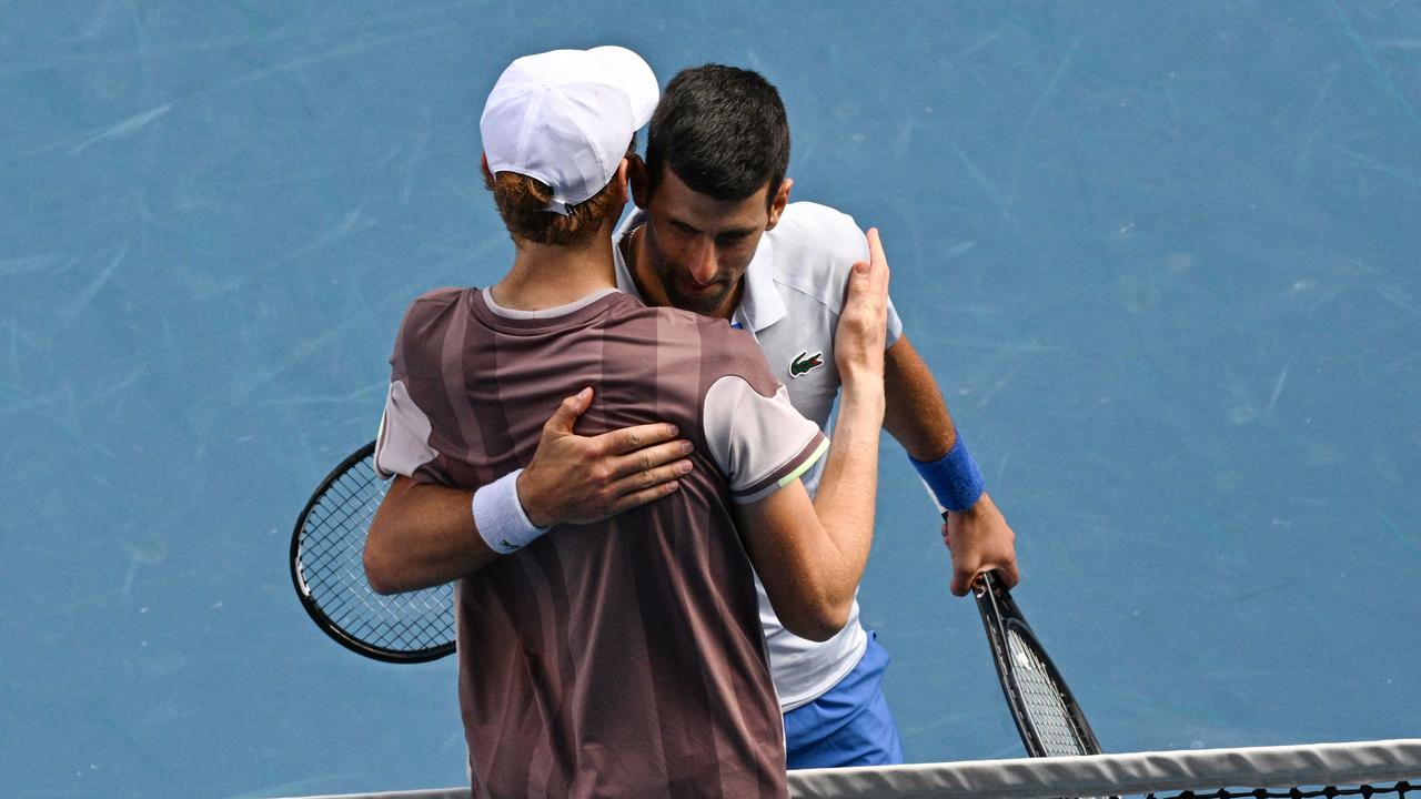 Jannik Sinner and Novak Djokovic embrace following the Italian’s semi-final victory. (Photo by Anthony WALLACE / AFP)