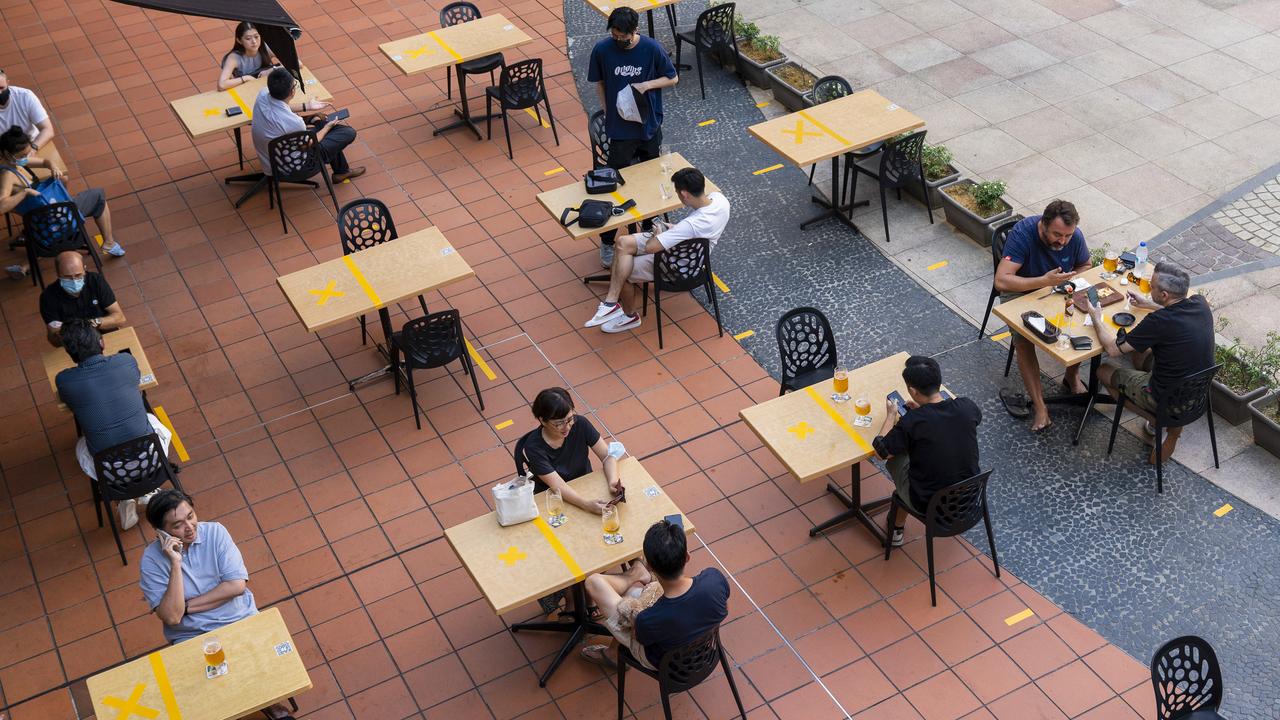 Customers sit at socially distanced tables outside a restaurant in Singapore. Photographer: Wei Leng Tay/Bloomberg via Getty Images