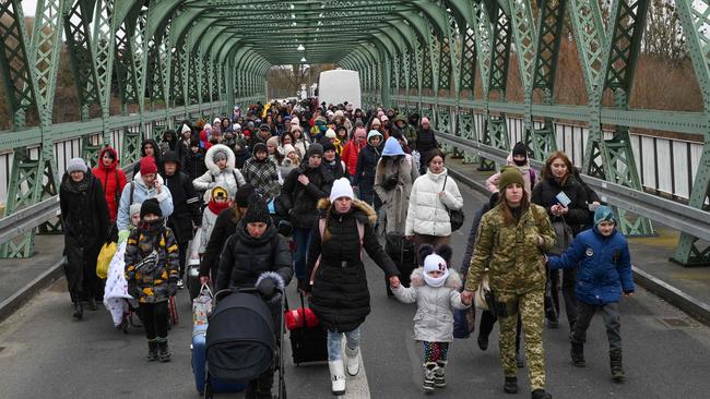 Ukrainian refugees walk a bridge at the buffer zone with the border with Poland in the border crossing of Zosin-Ustyluh, western Ukraine on March 6, 2022 Picture Daniel LEAL / AFP