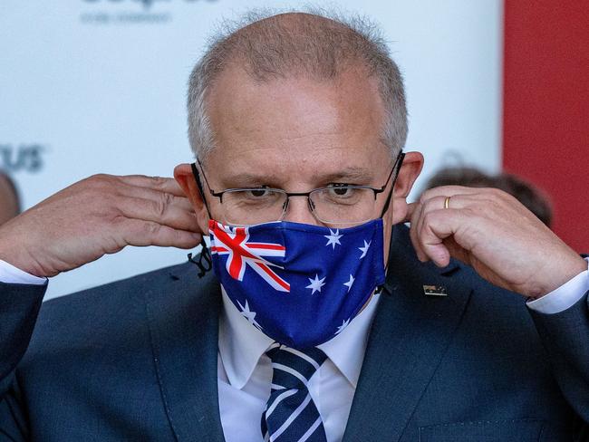 MELBOURNE, AUSTRALIA - NOVEMBER 16: Prime Minister Scott Morrison puts on a face mask during a press conference at CSL Lab where a COVID-19 Vaccine is being produced on November 16, 2020 in Melbourne, Australia. The federal government has announced a $1.8 billion agreement with pharmaceutical company CSL to construct a new biotech and vaccine manufacturing plant in Melbourne. The plant - to be the largest in the southern hemisphere - will deliver the first population-wide pandemic and seasonal flu vaccines for Australians, safeguarding the nation from global supply chain shortages or queues. (Photo by Darrian Traynor/Getty Images)