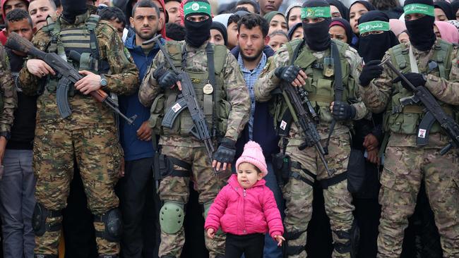 A child looks on as Palestinians and Hamas fighters gather shortly before the release three Israeli hostages. Picture: AFP.