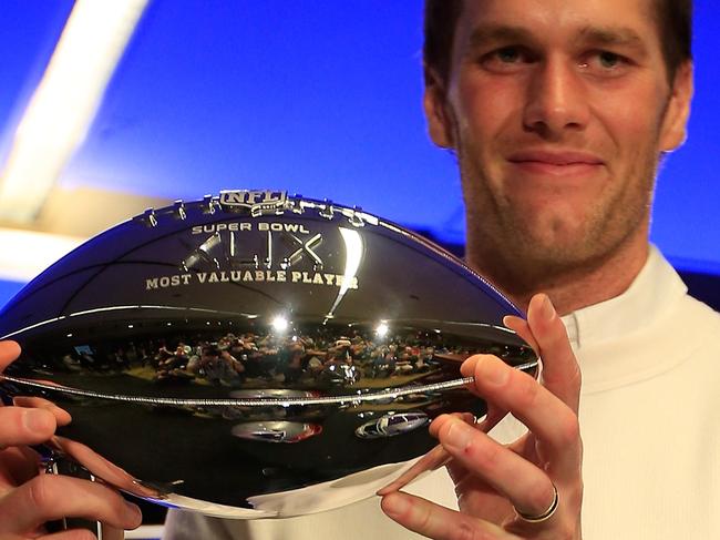 PHOENIX, AZ - FEBRUARY 02: (L-R) Tom Brady of the New England Patriots holds the Super Bowl XLIX MVP trophy during a Chevrolet Super Bowl XLIX MVP press conference folowing the Patriots Super Bowl win over the Seattle Seahawks on February 2, 2015 in Phoenix, Arizona. Jamie Squire/Getty Images/AFP == FOR NEWSPAPERS, INTERNET, TELCOS & TELEVISION USE ONLY ==