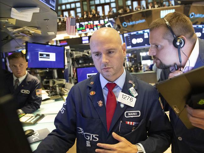 Mario Picone, center, and Michael Milano, right, work at the New York Stock Exchange, Monday, Sept. 16, 2019. Global stock markets sank Monday after crude prices surged following an attack on Saudi Arabia's biggest oil processing facility. (AP Photo/Mark Lennihan)