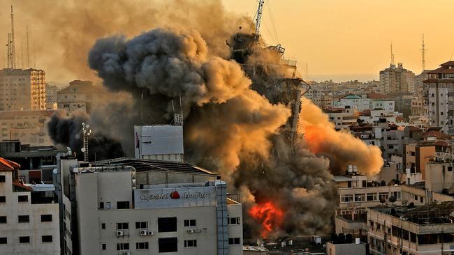 Heavy smoke and fire rise from Al-Sharouk tower as it collapses after being hit by an Israeli air strike, in Gaza City on May 12. Picture: AFP