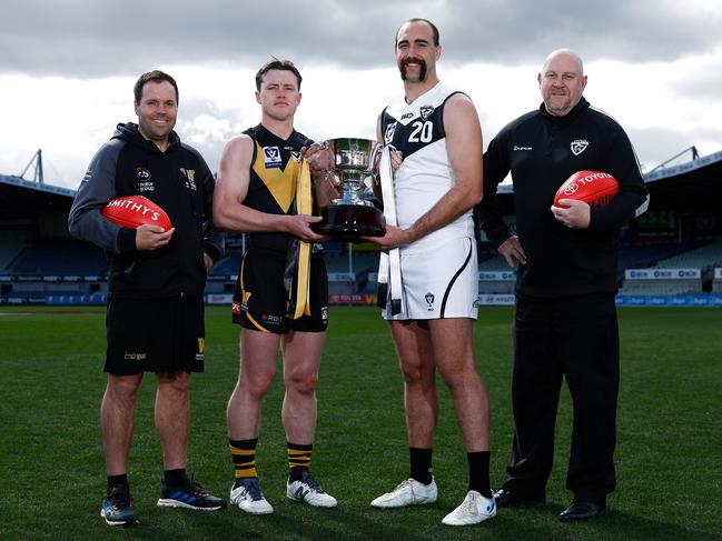 Werribee coach Jimmy Allan, captain Dom Brew, Southport Sharks captain Brayden Crossley and coach Steve Daniel pose with the trophy ahead of the VFL grand final. Picture: Michael Willson/AFL Photos