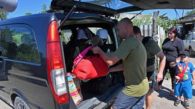 Volunteers help local residents to evacuate a village, near Kupiansk. Picture: AFP