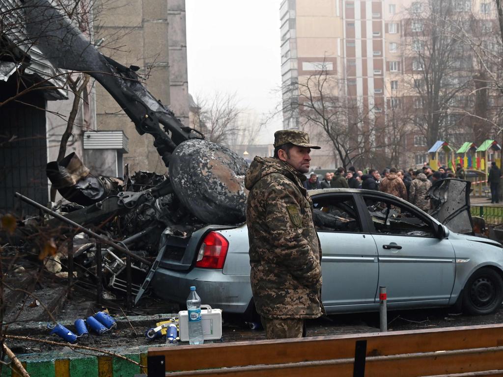 A soldier stands at the site where a helicopter crashed near a kindergarten outside the capital Kyiv, killing 18 people, including two children and Ukrainian interior minister, on January 18, 2023, amid the Russian invasion of Ukraine. (Photo by Sergei SUPINSKY / AFP)