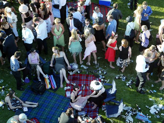 Punters make the most of new friendships and the afternoon sun after the last race at Flemington. Derby day.