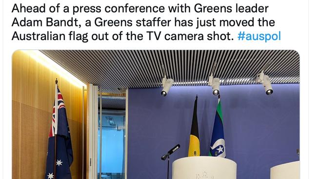 Ahead of a press conference with Greens leader Adam Bandt, a Greens staffer has just moved the Australian flag out of the TV camera shot. Picture: Twitter