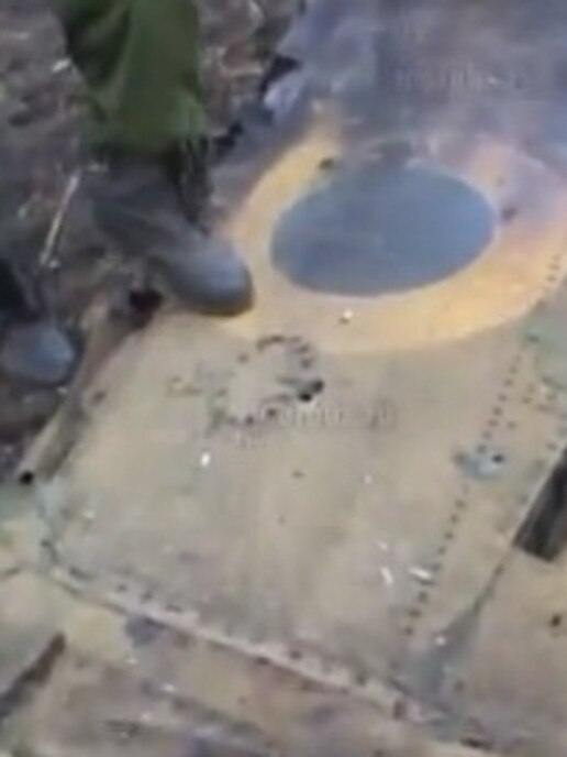 A soldier steps of the wing on the plane.