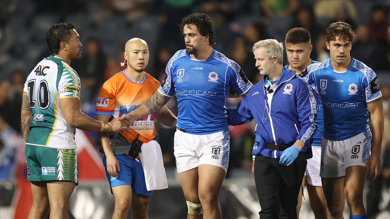 SYDNEY, AUSTRALIA - JUNE 25: Tinirau Arona of Cook Islands shakes hands with Josh Aloiai of Samoa as he is assisted from the field during the Men's International Test Match between Samoa and the Cook Islands at Campbelltown Sports Stadium on June 25, 2022 in Sydney, Australia. (Photo by Mark Kolbe/Getty Images)