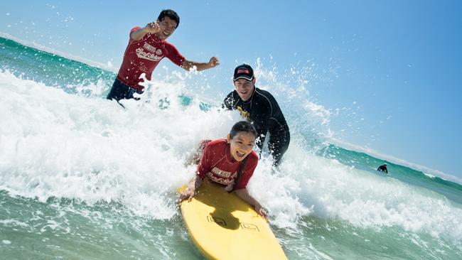 Tourism &amp; Events Queensland image of tourists surfing on the Gold Coast.