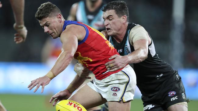 Tom Rockliff tackles former Lions teammate and midfield gun Dayne Zorko. Picture SARAH REED