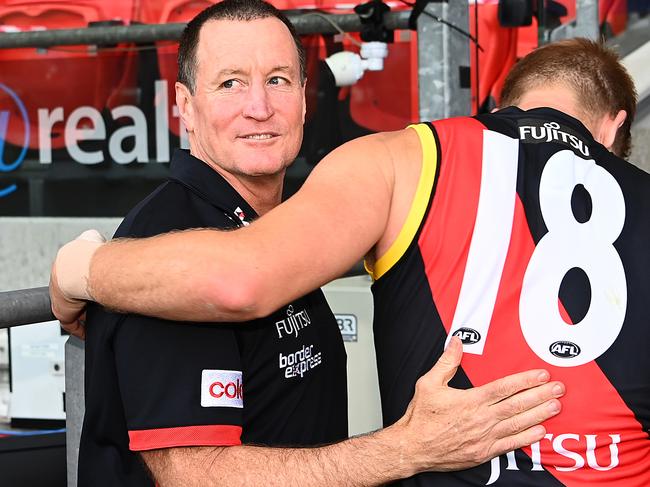 GOLD COAST, AUSTRALIA - SEPTEMBER 19: Bombers head coach John Worsfold hugs Michael Hurley of the Bombers after coaching in his final game during the round 18 AFL match between the Essendon Bombers and the Melbourne Demons at Metricon Stadium on September 19, 2020 in Gold Coast, Australia. (Photo by Quinn Rooney/Getty Images)