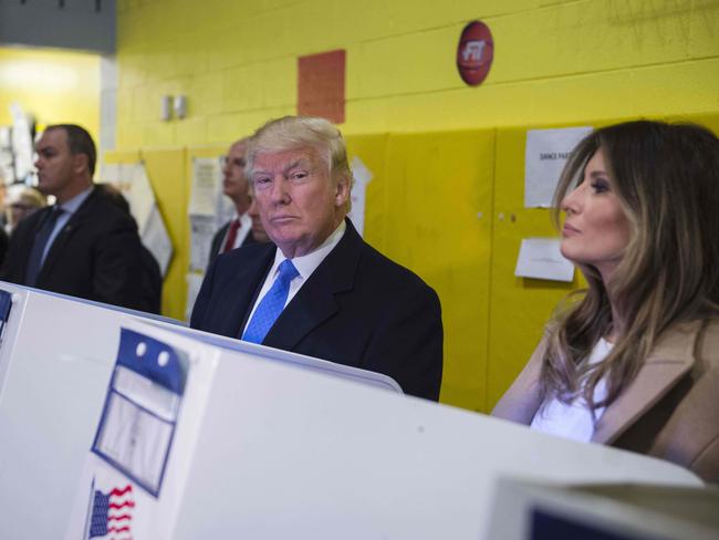 Republican presidential nominee Donald Trump(2nd R) and his wife Melania fill out their ballots at a polling station in a school during the 2016 presidential elections on November 8, 2016 in New York. / AFP PHOTO / MANDEL NGAN