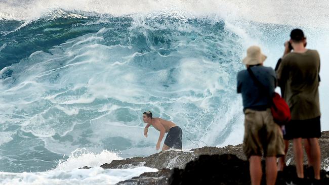 Photographers take photographs of a surfer at Snapper Rocks on the Gold Coast , Thursday February 21, 2019. Huge swells and high tides are set to pummelling south-east Queensland beaches over the coming days as Cyclone Oma tracks towards the Queensland coast. Photo: Dave Hunt/AAP.