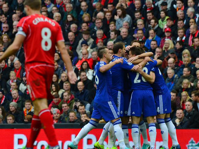 Chelsea players (R) celebrate their equalising goal scored by Chelsea's English defender Gary Cahill as Liverpool's English midfielder Steven Gerrard (L) walks by during the English Premier League football match between Liverpool and Chelsea at Anfield in Liverpool, north west England on November 8, 2014. AFP PHOTO / PAUL ELLIS RESTRICTED TO EDITORIAL USE. No use with unauthorized audio, video, data, fixture lists, club/league logos or “live” services. Online in-match use limited to 45 images, no video emulation. No use in betting, games or single club/league/player publications.