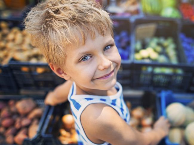 Happy little boy buying local groceries food at the tuscanian farmer's market at Cecina. Italy, Tuscany.  iStock generic markets shopping