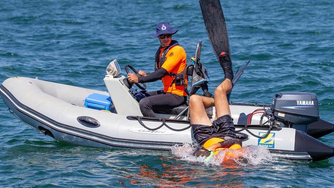 Victorian Fisheries Authority Officer Ashley dives off Williamstown as Senior Fisheries Officer Eric watches on. Picture: Mark Stewart