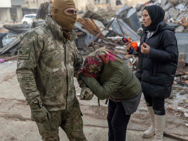 A woman pleads to a Turkish soldier to save her son, next to the rubble of a collapsed building in Hatay, southeastern Turkey. Picture: AFP