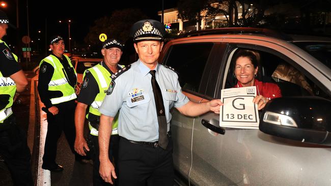 Queensland Police Superintendent Mark Wheeler takes back a Queensland border pass after the closure was lifted at 1am. Picture: Scott Powick