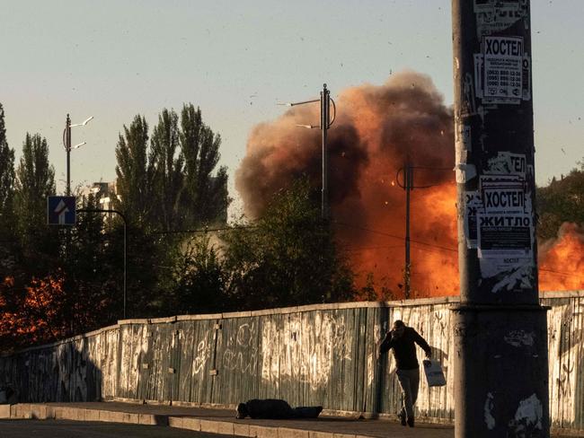 A man falls is seen on the ground after a blast following a drone attack in Kyiv on October 17, 2022, amid the Russian invasion of Ukraine. (Photo by Yasuyoshi CHIBA / AFP)