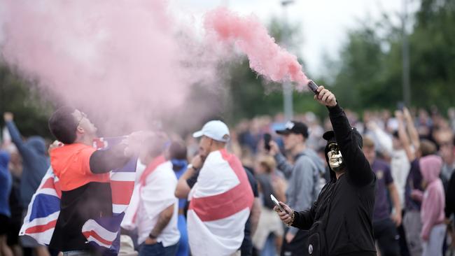 Flag-draped anti-migration rioters outside a Holiday Inn Express in Rotherham, which is being used as an asylum hotel, on Sunday. Picture: Christopher Furlong/Getty Images