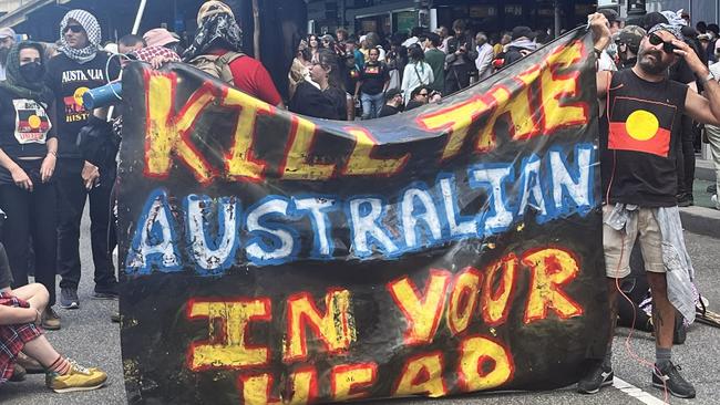 26-01-2024 - Attendees holding signs at an Invasion Day rally in Melbourne. Picture: Tricia Rivera