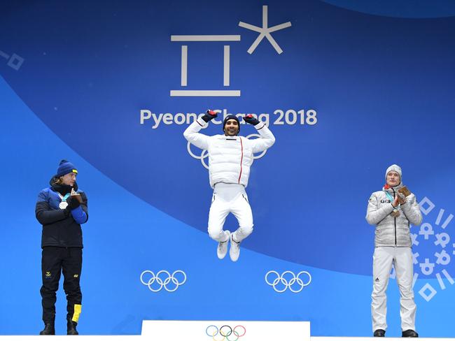 France’s gold medallist Martin Fourcade (C) jumps on the podium between Sweden’s silver medallist Sebastian Samuelsson (L) and Germany’s bronze medallist Benedikt Doll during the medal ceremony for the biathlon men’s 12.5km pursuit at the Pyeongchang Medals Plaza during the Pyeongchang 2018 Winter Olympic Games in Pyeongchang on February 13, 2018. Picture: AFP