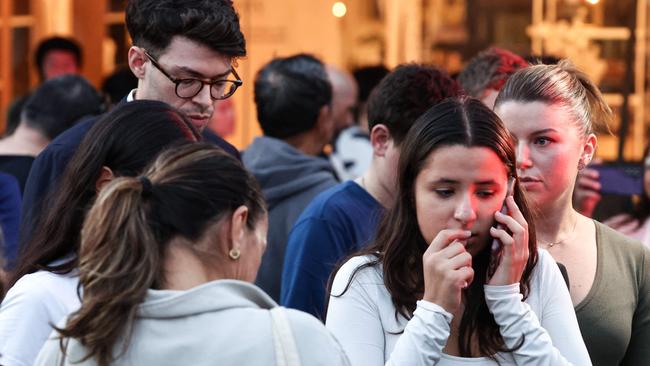 TOPSHOT - People react outside the Westfield Bondi Junction shopping mall after a stabbing incident in Sydney on April 13, 2024. Australian police on April 13 said they had received reports that 