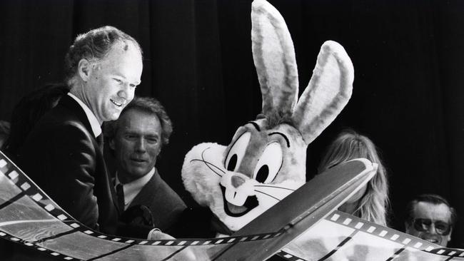 Premier Wayne Goss cuts the film at the opening of Movie World with actor Clint Eastwood and Bugs Bunny.