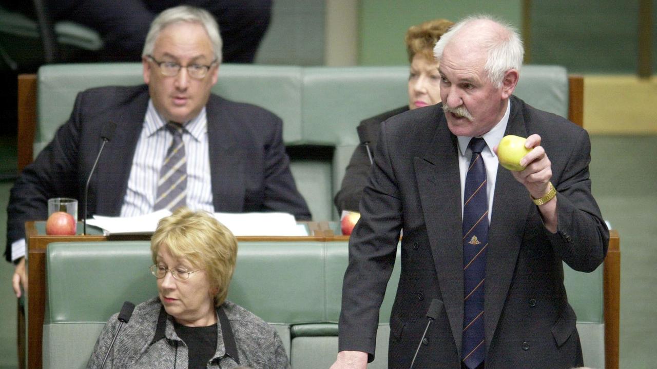 Labor MP Harry Quick holds an apple in protest during Question Time in House of Representatives of Federal Parliament in Canberra.