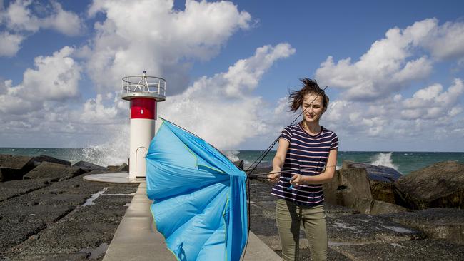 Tarsha Talebi struggling with her umbrella in the strong winds at the Spit. Picture: Jerad Williams