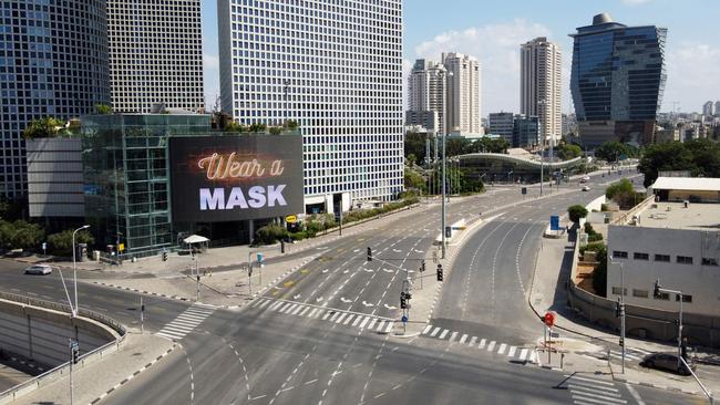 A billboard reminding people to wear masks in an almost deserted street in the centre of Tel Aviv. Picture: AFP.