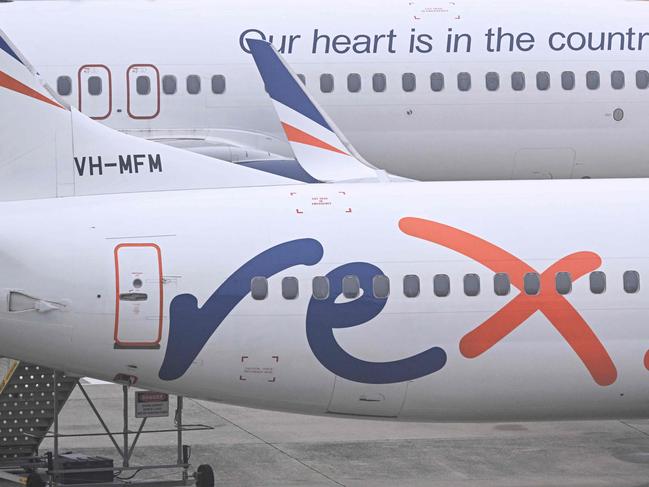 Rex Airlines Boeing 737 planes lay idle on the tarmac at Melbourne's Tullamarine Airport on July 31, 2024. The Australian regional airline Rex cancelled flights as it entered voluntary administration on July 31, leaving the fate of the country's third-largest carrier in serious doubt. (Photo by William WEST / AFP)