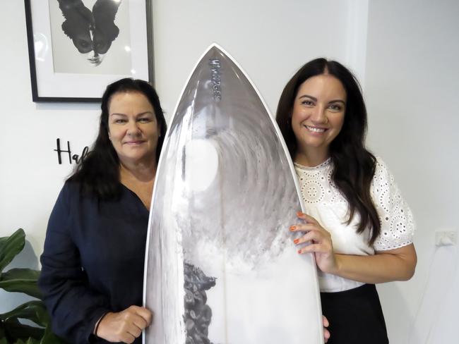 Judy Littler (left) won a custom made Mt Woodgee surf board, among other prizes, after buying tickets for a fundraiser to support wildlife organisations supporting bushfire affected animals. Rachel Hannah (right) was just one of 12 salons across the Tweed and Gold Coast who organised the event.