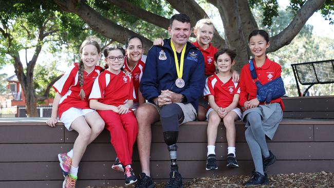 Invictus Games Athlete and Former Army Commando, Garry Robinson is pictured at Canterbury South Public School with (left) Elizabeth Turner, 8, Georgia Scrivener, 9, Melia Antonopolous ,10, Alice Bursill Dickinson, 9, Elliot Foxlee, 8, and Beatrice Shimada, 9, who have written letters to encourage the athletes. Picture: David Swift.